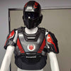 A black and red futuristic armored chest plate with matching helmet displayed on a white mannequin torso in an indoor room.
