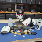 Weapon on a table with a blue flag featuring white stars, in an indoor setting.